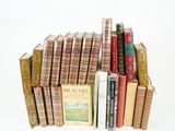 several books are stacked on top of each other on a white surface
