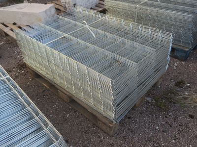 de nombreuses cages posées sur une palette, dans la boue