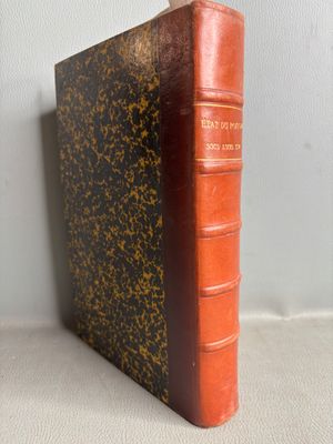 an old book sitting on top of a table next to a white wall