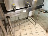 un évier en acier inoxydable dans une cuisine au sol carrelé