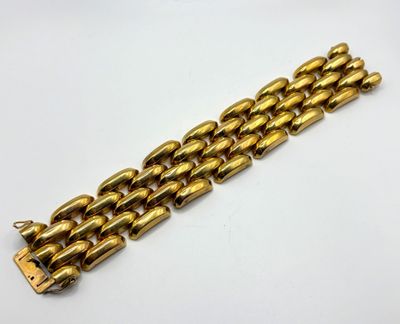 gros plan d'un bracelet en or sur une surface blanche