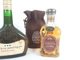 three bottles of liquor sitting next to each other on a white surface