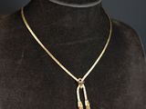 un collier en or orné d'un pompon autour du cou d'un mannequin
