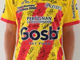 Cet homme porte un t-shirt jaune et rouge sur lequel figurent de nombreux autographes.
