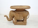 a wicker elephant table with a basket on top of it