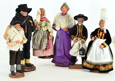 five figurines of people dressed in different costumes