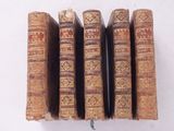 plusieurs vieux livres sont empilés sur une surface blanche