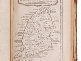 an old book with a map inside of it on a white surface