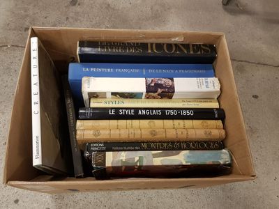 une boîte remplie de livres posée par terre