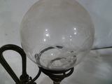 une lampe en verre posée sur un support sur une table