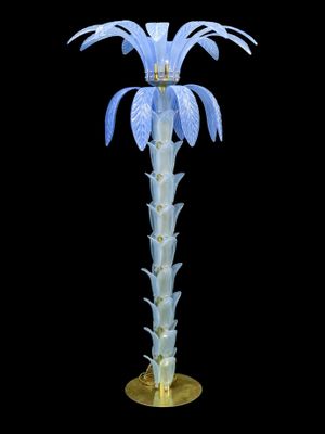 un grand vase en verre orné d'une fleur bleue