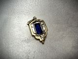 a close up of a pendant with a blue stone in it