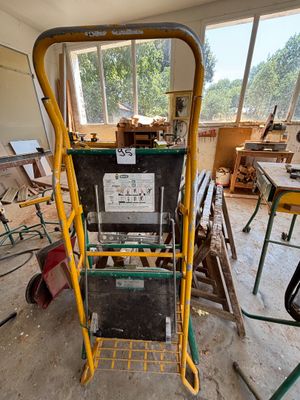 un chariot jaune et noir dans une pièce remplie d'outils