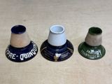 three small vases sitting on a table with a spool of thread
