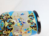 un vase bleu orné d'un oiseau, posé sur une table