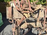 une charrette en bois sur laquelle se trouvent tout un tas d'objets rouillés