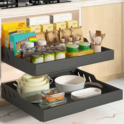 a black pull out shelf in the corner of a kitchen with dishes and utensils on it