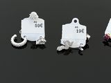 four different charms with price tags on them sitting on a black surface