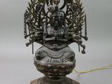 une image représentant une statue en bronze d'une personne assise sur un lotus