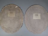 pair of old paper plates sitting on top of a blue table
