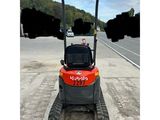a small tractor parked on the side of a road next to a road