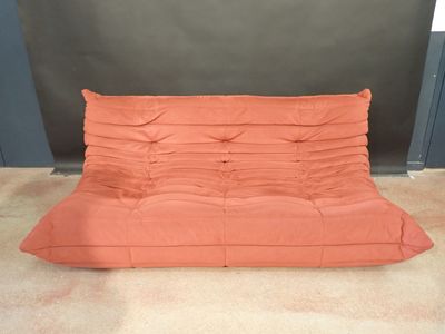 un canapé-futon orange sur lequel est posé un oreiller
