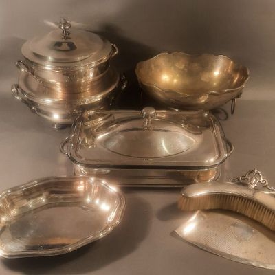 plusieurs couverts posés sur une table, à côté d'une brosse