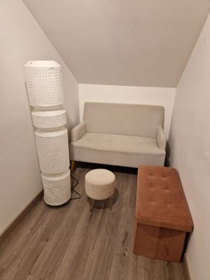 a room with a couch, a chair, and a lamp in it