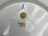 a close up of a white plate with a gold coin on it