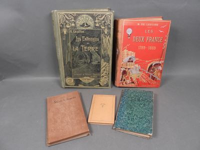 three books are sitting next to each other on a gray surface