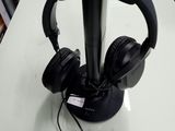 a black headphone stand with a pair of headphones on it