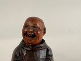 a small wooden statue of a laughing man on a table