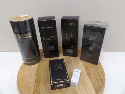 three boxes of perfume sitting on top of a wooden table