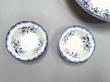 two blue and white plates and a bowl on a table