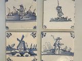 four blue and white tile paintings of a man and a woman on a boat