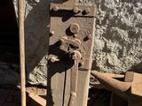 an old rusted iron door with a hammer next to it