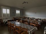many tables and chairs in a room with many windows