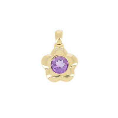 un pendentif en or jaune orné d'une pierre violette au centre