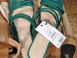 several pairs of women ' s shoes and a purse are in a box