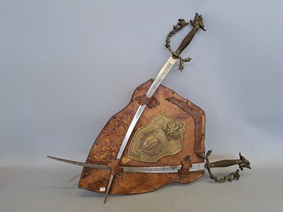une plaque en bois sur laquelle figure une épée, à côté d'une paire de ciseaux
