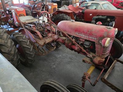 many old tractors in the garage of this building
