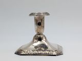 an image of a silver candle holder on a white surface
