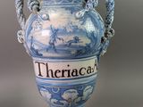 a blue and white vase with a rope around it