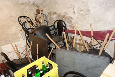 une pièce avec beaucoup de chaises, une chaise, une table et une caisse de bouteilles de bière