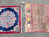 two oriental rugs on the ground, one is red and the other is blue
