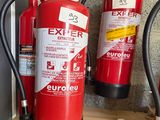 fire extinguisors are lined up on a shelf next to a wall