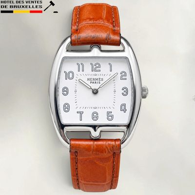 une image d'un gros plan d'une montre-bracelet sur une surface blanche