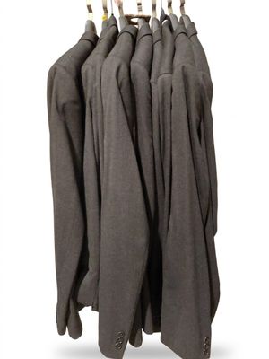 five suits hanging on a clothes rack on a white background