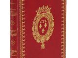un livre rouge avec des bordures dorées et une couronne sur la couverture