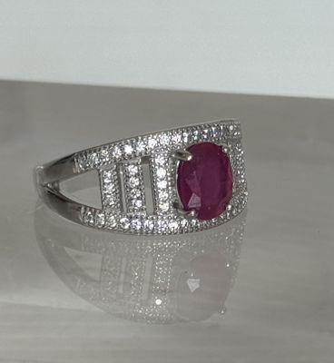 une photo d'une bague sertie d'un rubis et de diamants, posée sur une table